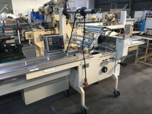 PFM MOTORISED FLOW WRAPPING MACHINE Model: PFM-30 with Approx 200mm Rubber Belt Infeed Conveyor, Take-Out Conveyor, Overhead Wrap Feed-Out Station, Control to 415V 3 Phase Electric Motor and Switch on Mobile Base